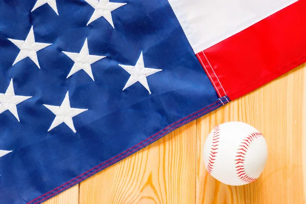 Pelota de béisbol y bandera americana en tablas de madera vista desde arriba — Foto de Stock