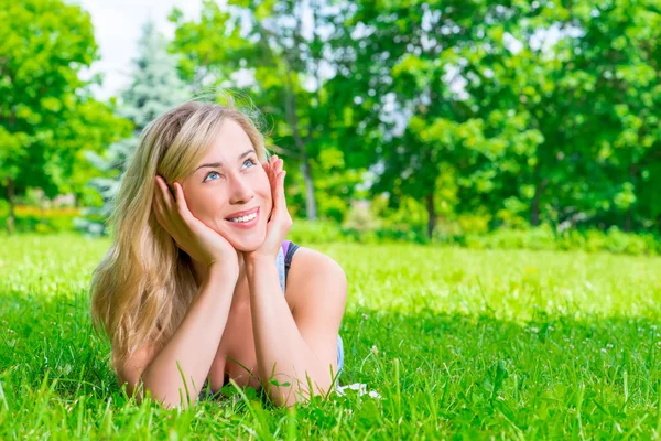 Beautiful woman dreams of lying on the green grass Royalty Free Stock Images