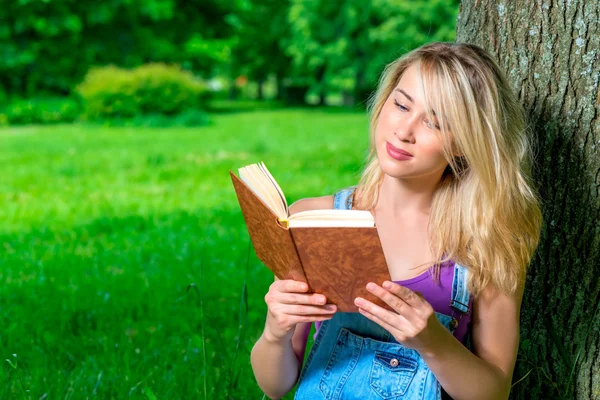 Retrato de un estudiante con un libro en el parque — Foto de Stock