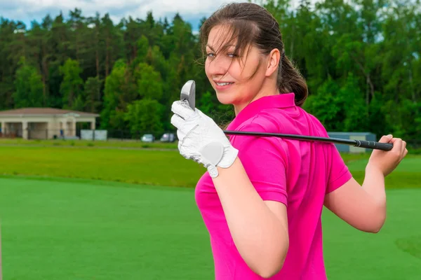 Dívka pózuje na pole s golfový klub — Stock fotografie