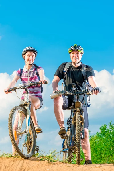 Vertical shot of a smiling couple on a bicycle — Stock Photo, Image