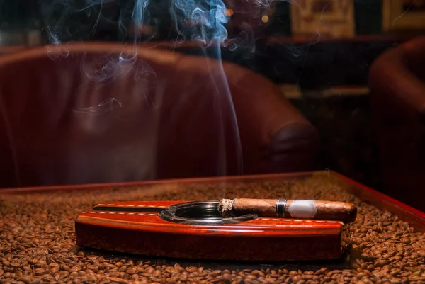 Un cigare cher fumeur dans le cendrier sur la table — Photo