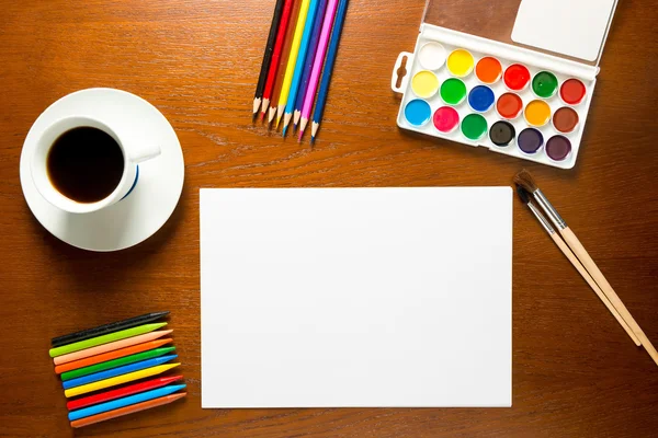 Herramientas de dibujo en una vista superior de la mesa y una hoja de papel en blanco —  Fotos de Stock