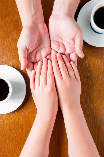 Mãos masculinas e femininas na mesa com xícaras de café — Fotografia de Stock