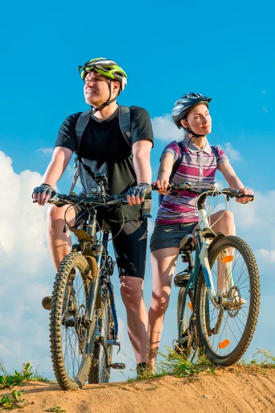 Young cyclists on mountain covered rays of sun — Stock Photo, Image