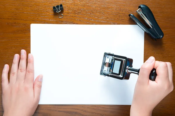 Mains mettre un timbre sur la feuille vierge de papier — Photo