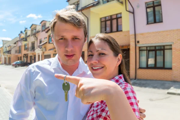 Junges Ehepaar zeigt Schlüssel für neues Haus. Fokus auf die k — Stockfoto