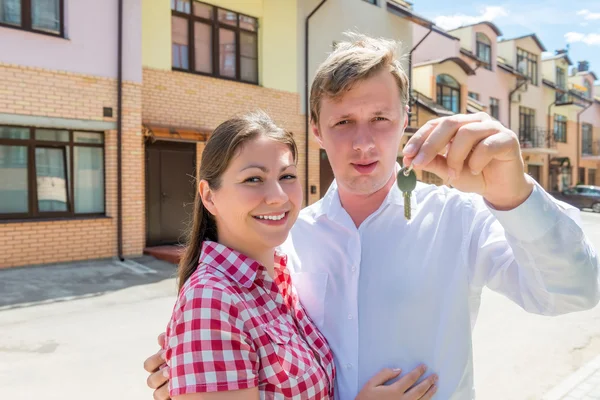 Mann zeigt Hausschlüssel und umarmt Ehefrau — Stockfoto