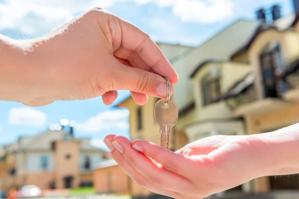 Transfer ke pembeli rumah kunci close-up tangan terhadap — Stok Foto