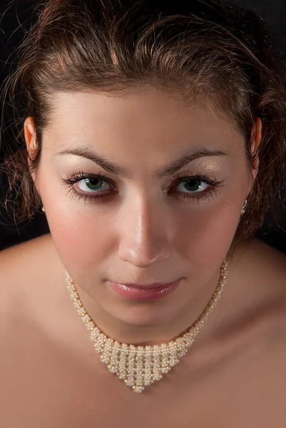 Portret van een brunette met een ketting van kralen close-up — Stockfoto