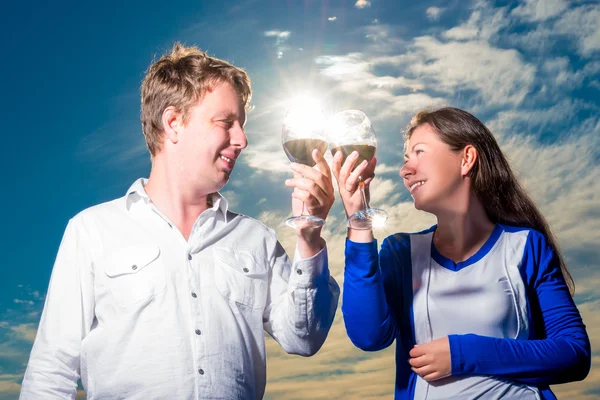 Glückliches Paar mit Weingläsern im Sonnenstrahl — Stockfoto