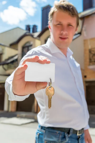 Porträt eines Mannes mit einem Schlüssel des neuen Hauses Fokus auf den Schlüssel — Stockfoto