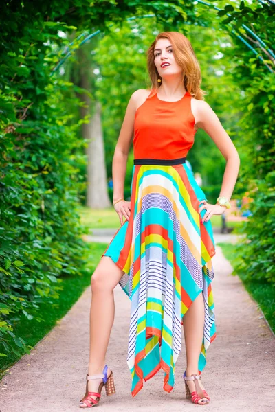 Modell i en vacker klänning som poserar i parken sommaren — Stockfoto