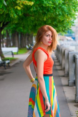 Waterfront parlak bir elbise genç güzel kız yürüyor