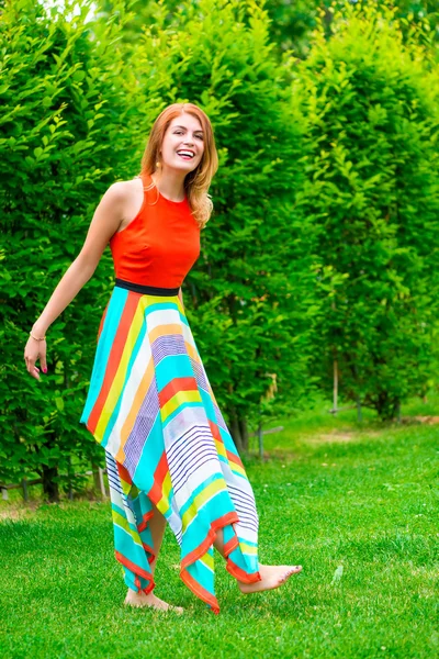 Menina descalça em um vestido em um gramado no parque — Fotografia de Stock