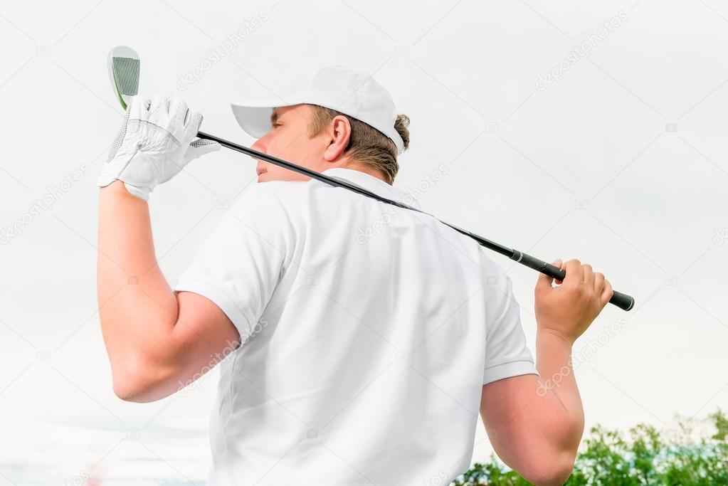 man holding a golf club behind his back