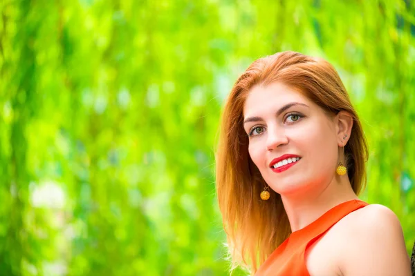 Hermoso rostro de niña sobre un fondo de verde parque — Foto de Stock