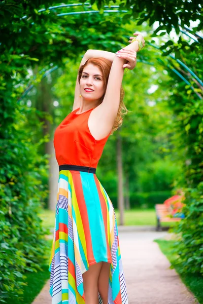 Retrato de una niña en un arco verde en el parque — Foto de Stock