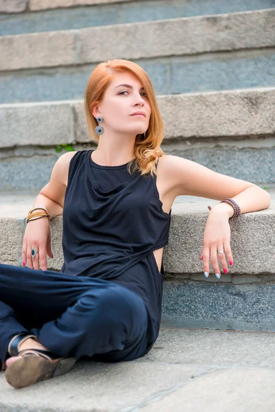 Симпатичная девушка, сидящая на бетонной лестнице — стоковое фото
