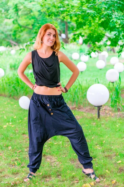 Стройная модная женщина в черной одежде в парке — стоковое фото