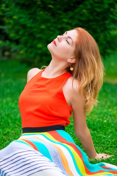 Bright woman relaxing on the lawn in the park — Stock Photo, Image