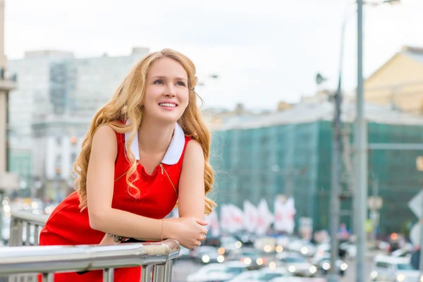 Porträt einer Blondine, die sich an das Balkongeländer lehnt — Stockfoto