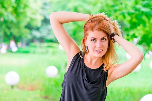 Portret van een stijlvolle jonge vrouw in een zomer park — Stockfoto