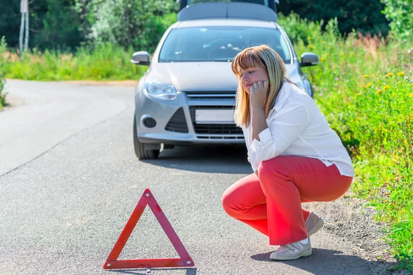 Donna sconvolta sulla strada vicino alla macchina rotta — Foto Stock