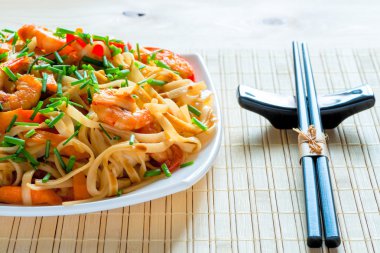 chopsticks and a large portion of Chinese food