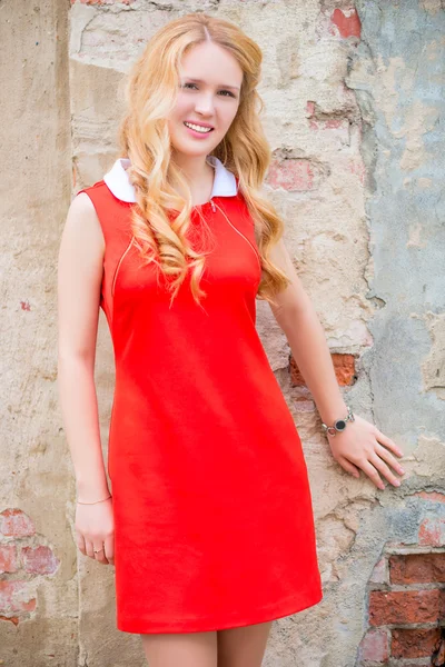 Young blond woman with curly hair in a red dress — Stock Photo, Image