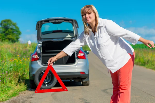 Femelle 50 ans, se met sur le triangle de signalisation routière — Photo