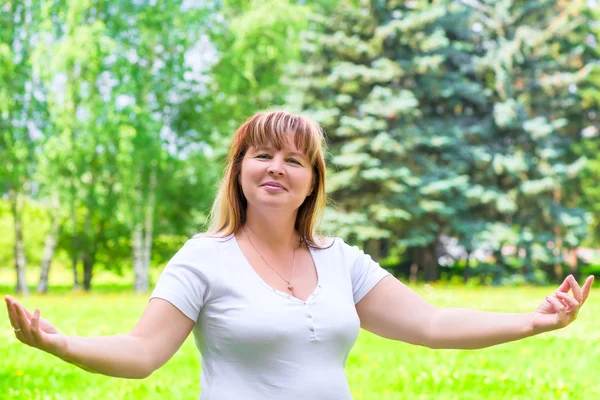 50-jährige Frau posiert im Park im weißen Hemd — Stockfoto