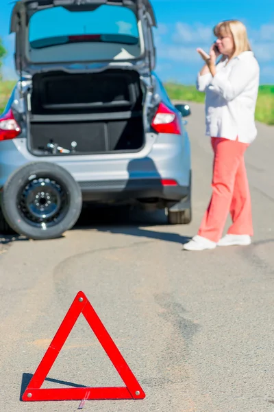 Mature female driver calls on the phone for help — Stock Photo, Image