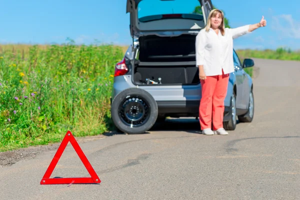 Starší ženy požádal o pomoc na silnici poblíž rozbité auto — Stock fotografie