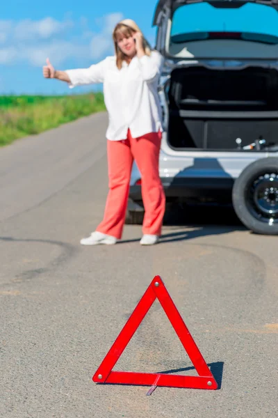 電話で助けを求めて道路で女性ドライバー — ストック写真