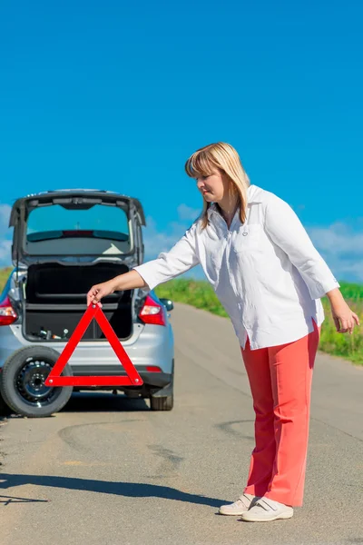 Vertikales Bild reife Frau wird Warndreieck auf t installiert — Stockfoto