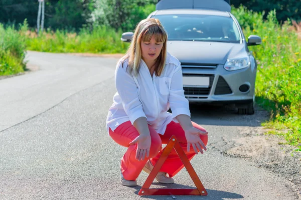 Lady over uw auto en gevarendriehoek — Stockfoto
