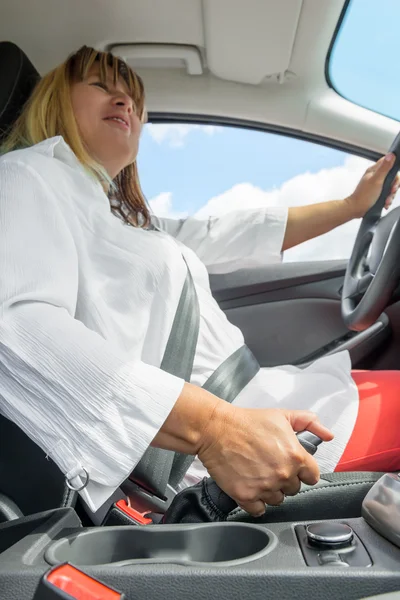 Portret kobiety w samochodzie trzymając hamulec postojowy — Zdjęcie stockowe