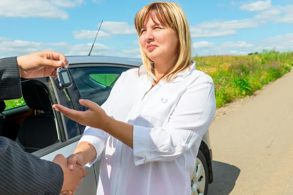 Mujer 50 años, compró un coche nuevo y conseguir la llave — Foto de Stock