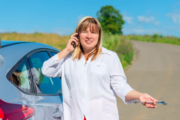 Retrato de una mujer de 50 años, llamando a un mecánico de automóviles por p —  Fotos de Stock