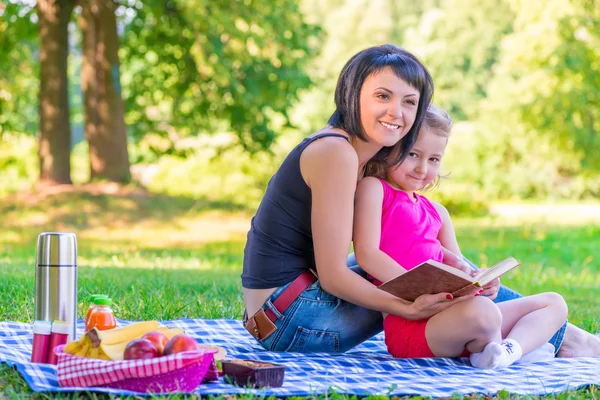 Madre joven con su hija en un picnic — Foto de Stock