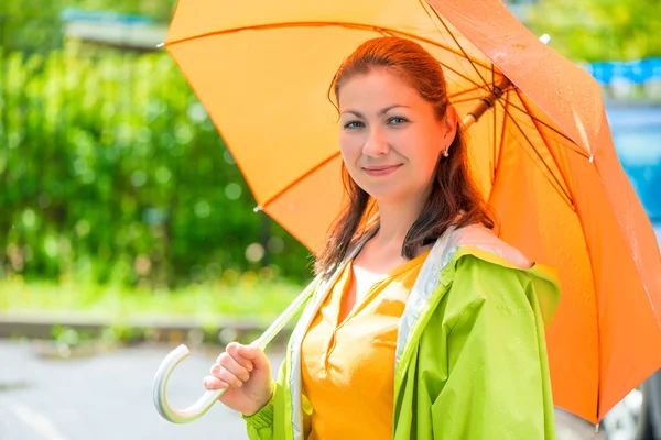 Portrait of a beautiful girl with an orange umbrella closeup — Stock Photo, Image
