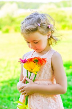 6 yaşındaki bir kız ile bir buket gerbera portresi