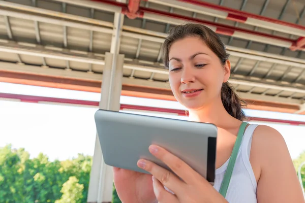 Portrait a pretty brunette with a tablet in hands — Stock Photo, Image