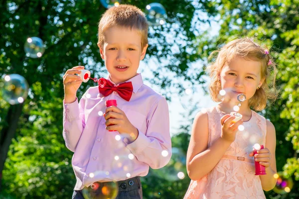 Horizontale shot kind met zeepbellen in het park — Stockfoto