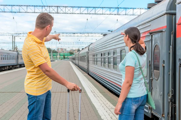 Pareja en la estación de tren esperando el tren — Foto de Stock