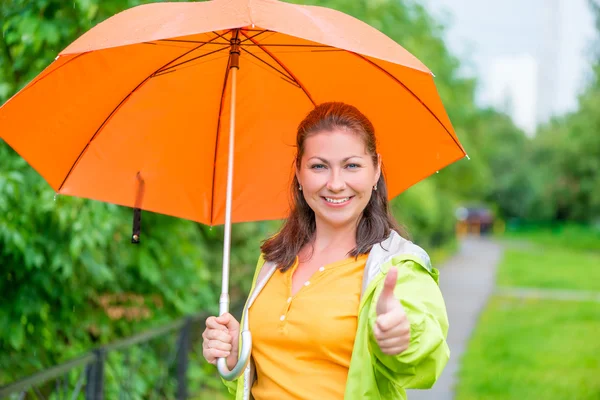 Femme satisfaite avec parapluie sur la promenade dans le parc — Photo