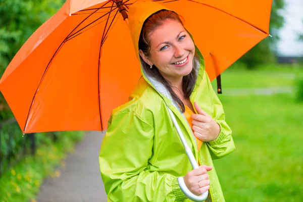 Brunette riant sous un parapluie orange gros plan — Photo