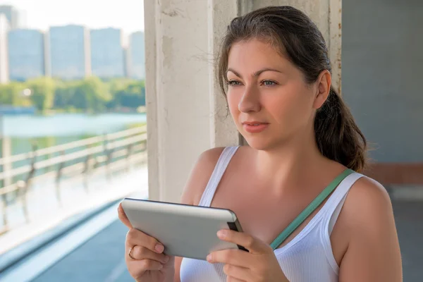 Beautiful woman with a tablet in urban locations — Stock Photo, Image