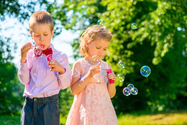 Meisje en haar vriend met zeepbellen in het park — Stockfoto